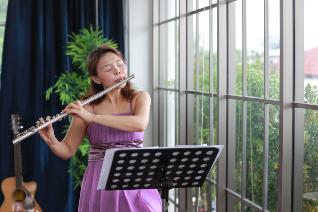 mujer jóven tocando la flauta clásica