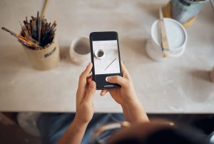 Persona tomando foto a una taza con su celular